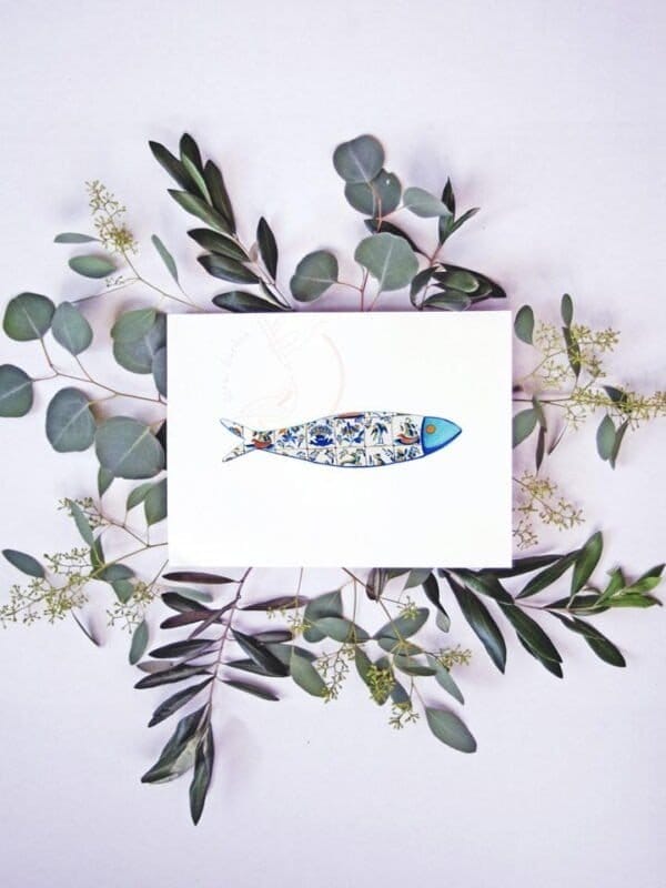 A card with a Tiles sardine print and eucalyptus leaves.
