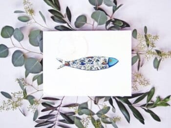 A card with a Tiles sardine print and eucalyptus leaves.