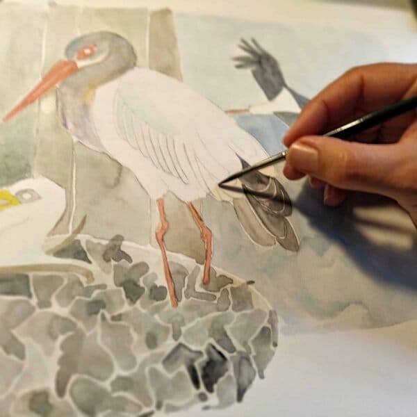 A person is creating a Black Stork Print on a piece of paper at Portugal Shop.
