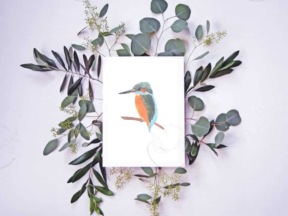 An art print of a Common kingfisher sitting on a branch with eucalyptus leaves, available at Portugal Shop.