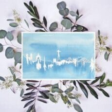 A Lisbon print depicting a blue card adorned with eucalyptus leaves, perfect for wall art.